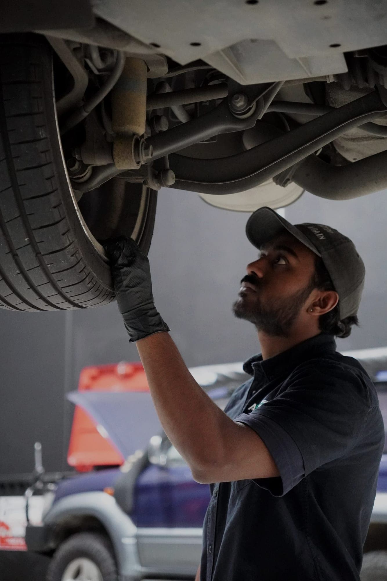 ASR technician inspecting the underside of a car on the hoist